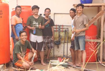 KKN-PPM UGM student team and the community were making water purification facility in KTM Rasau Jaya Office. Photo by Heru Wijaya